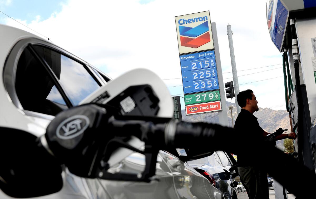 Motorists fill up at a Chevron station in Burbank in September. Gov. Brown is moving forward with his goal of cutting the state's petroleum use in half by 2030.