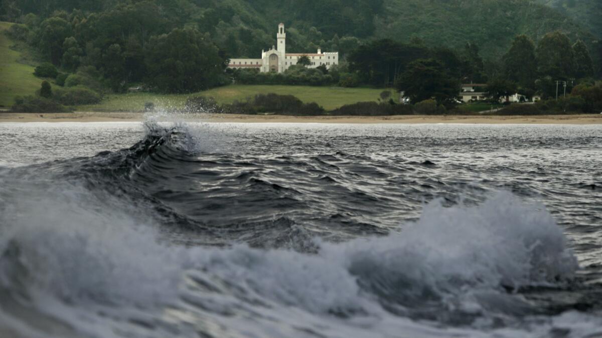 Waves break at Monastery Beach, with the Chapel of the Carmelite Monastery in the background, in Carmel in this 2013 file photo. A Scotsman was reported missing from the treacherous beach last week, but officials now think the man faked his own death.