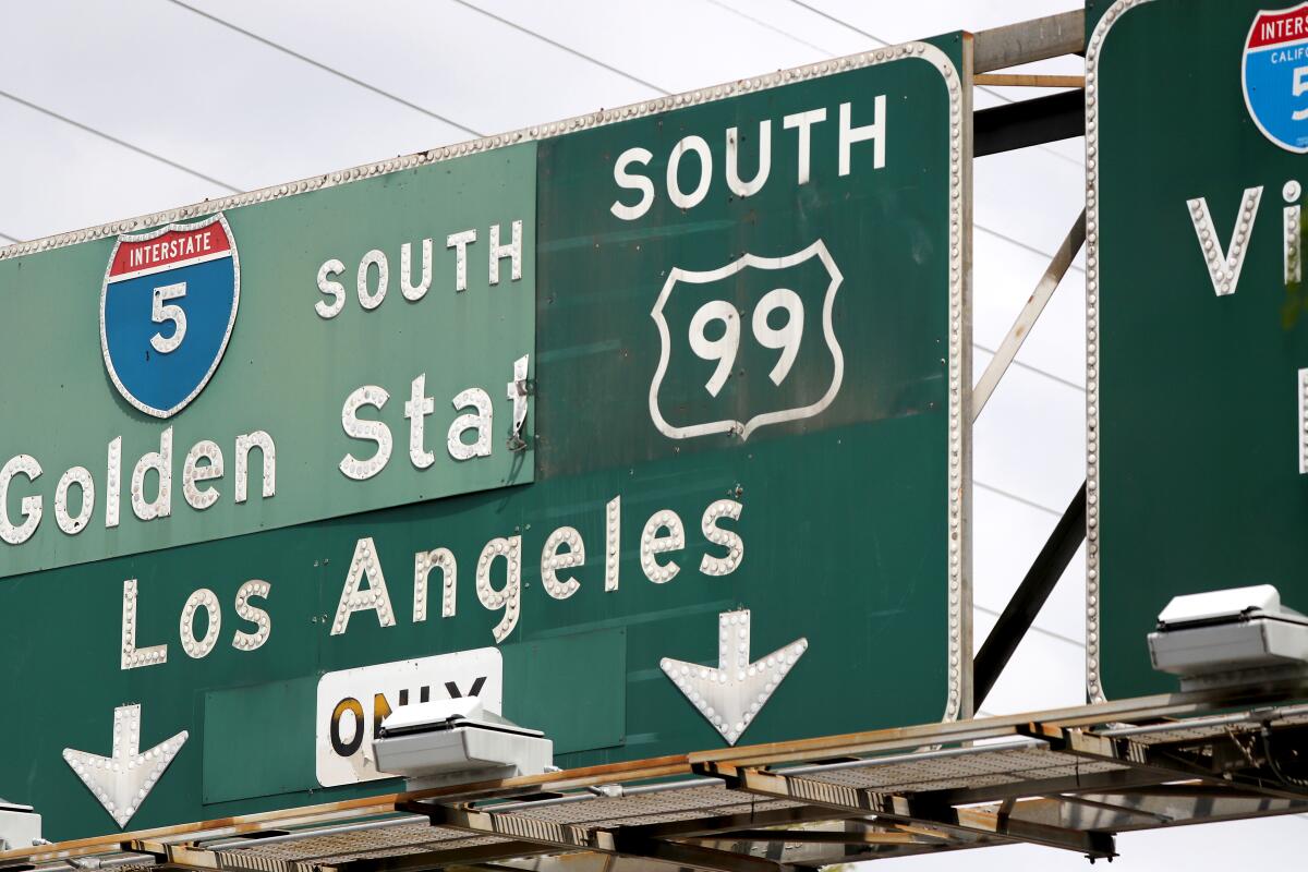 An old U.S 99 sign is revealed under a partial sign for Interstate 5  