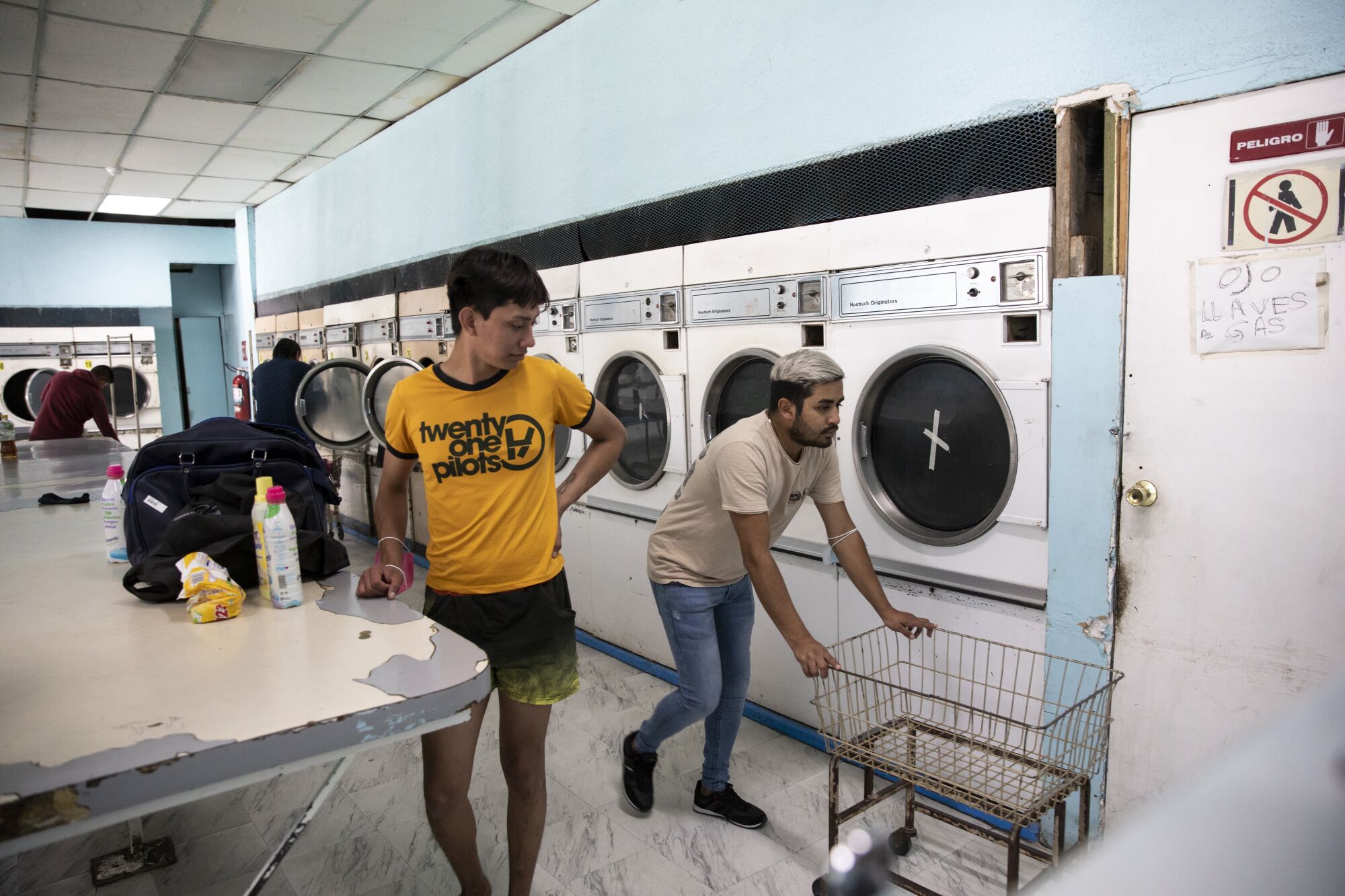 Ceidy Zethare and Julian Chacón do laundry in a laundromat