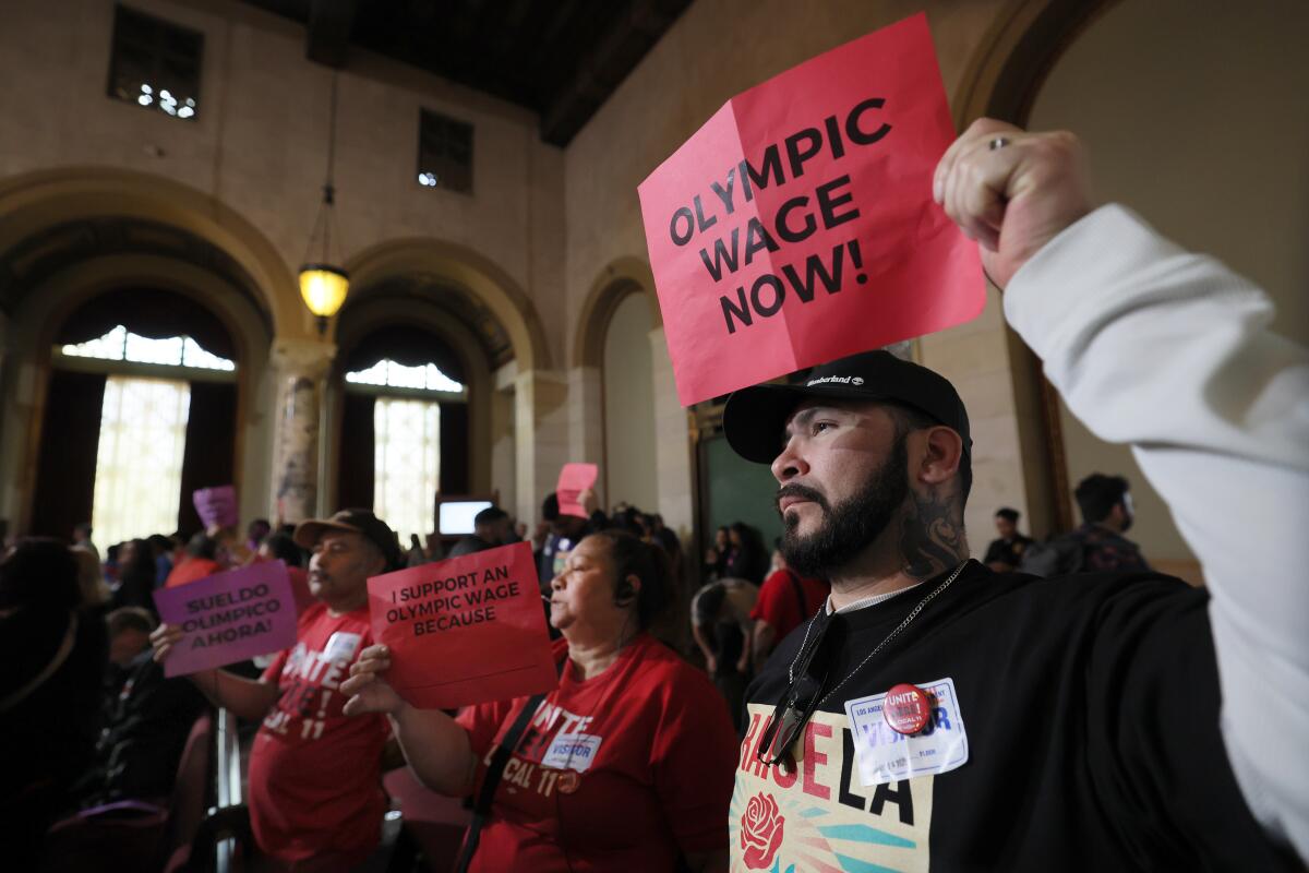 Manny Morales, right, and other demonstrators hold signs calling for higher wages