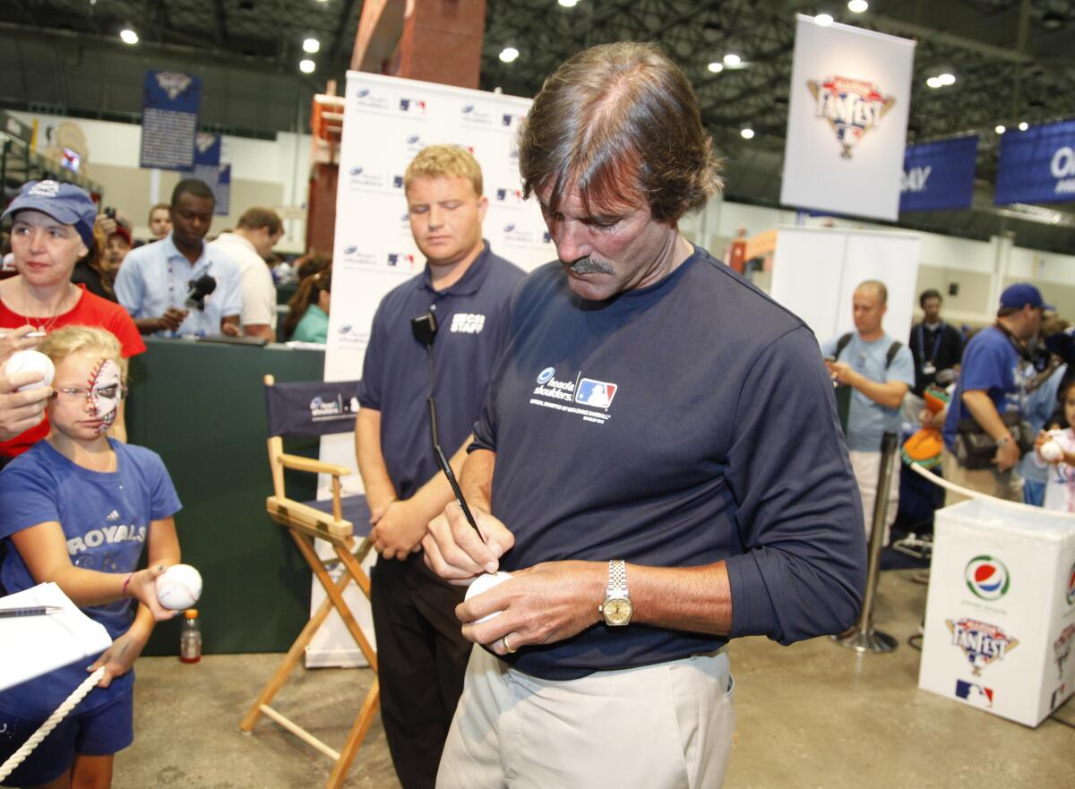 Hall of Fame reliever Dennis Eckersley signs autographs at an MLB Fan Fast in 2012.
