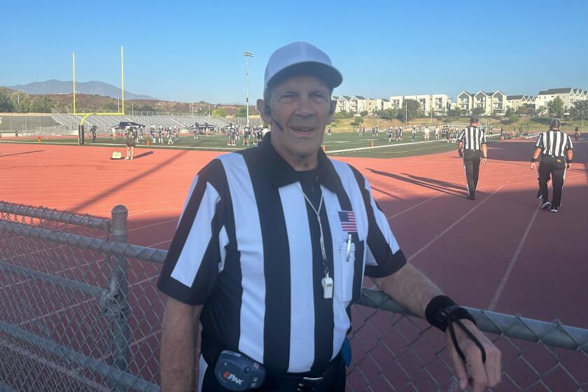 Brian Brennan poses for a photo before a high school football game he's about to officiate.