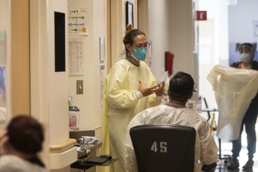 MISSION HILLS, CA - JANUARY 14: Palliative care physician Dr. Marwa Kilani, MD, talks with staff inside the covid unit at Providence Holly Cross Medical Center Thursday, Jan. 14, 2021 in Mission Hills, CA. (Francine Orr / Los Angeles Times)