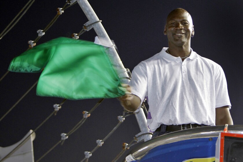 FILE - In this May 22, 2010, file photo, Charlotte Bobcats owner Michael Jordan practices waving the green flag before a NASCAR All-Star auto race at Charlotte Motor Speedway in Concord, N.C. NASCAR needs to roll out the red carpet when the Daytona 500 opens the season Sunday. Michael Jordan and the rapper Pitbull, racing’s newest team owners, are expected to attend. (AP Photo/Chuck Burton, File)