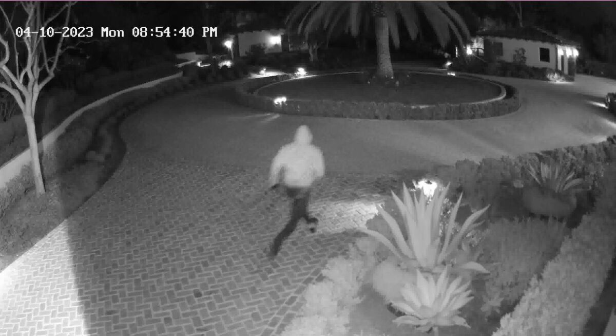 One of two home burglary suspects runs down a Rancho Santa Fe driveway.