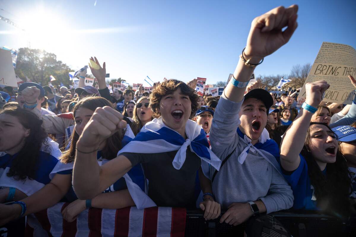 Demonstrators, some with Israeli flags, gesture and chant.