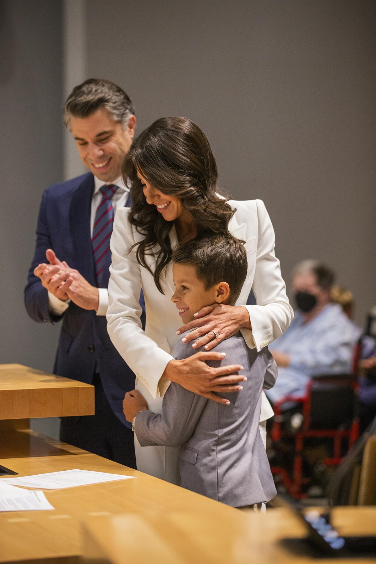 Lauren Kleiman hugs her son Pierce as her husband Marc looks on after being sworn in.