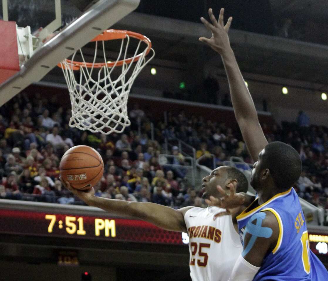 USC guard Byron Wesley goes in for a layup against the defense of UCLA center Anthony Stover in the second half Sunday night at the Galen Center, where UCLA claimed a 66-47 victory.