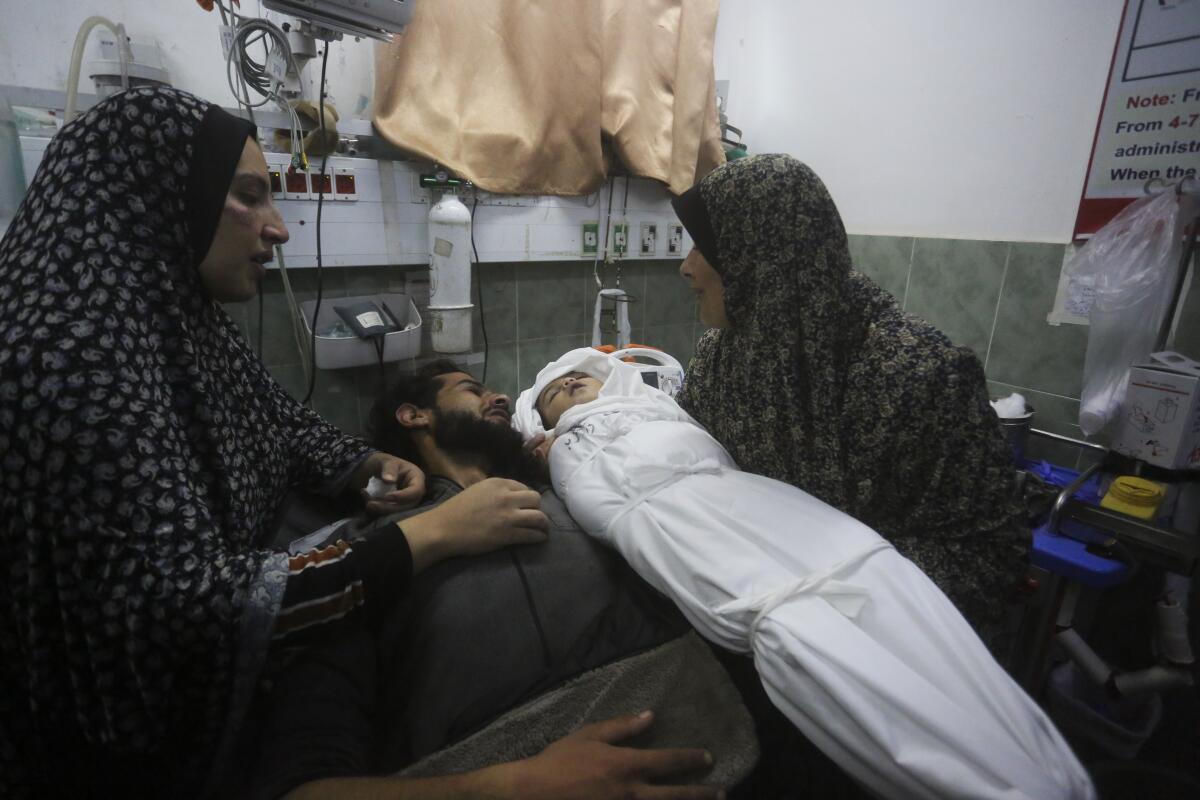 Una palestina muestra el cadáver de su nieta al padre de la beba