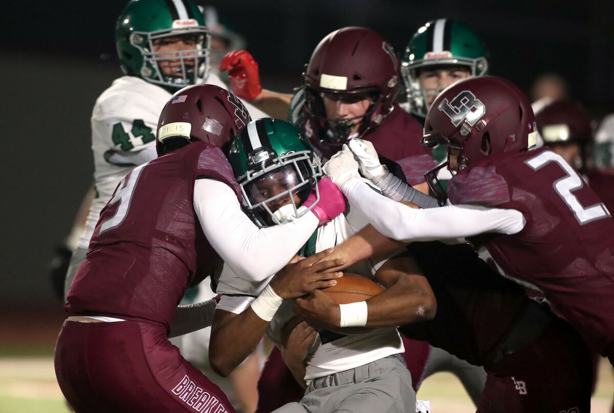 Granada Hills Charter running back Darrell Stanley is stopped at the line of scrimmage by a host of Laguna Beach tacklers.