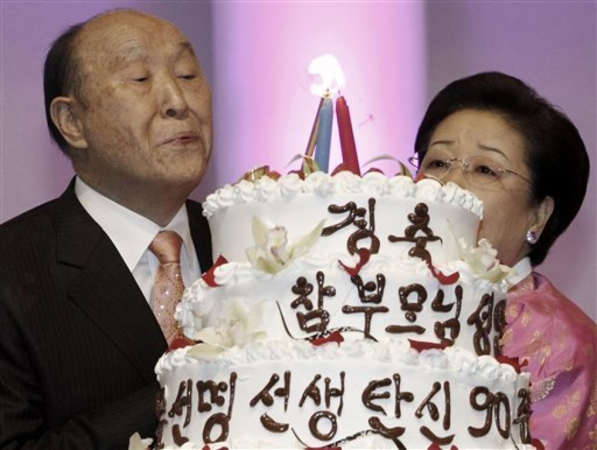 Rev. Moon Sun-myung, left, founder of the controversial Unification Church, with his wife Han Hak-ja blows out the candles on a cake at his birthday party in Gapyeong, South Korea, Friday, Feb. 19, 2010. Guests from around the world sang, prayed and shouted "Hurrah" Friday to celebrate the Rev. Moon's 90th birthday as he is preparing to hand over control of the Unification Church to a Harvard-educated son, Rev. Moon Hyung-jin. The cake reads "Congratulations! Rev. Moon Sun-myung's 90th birthday." (AP Photo/Ahn Young-joon)