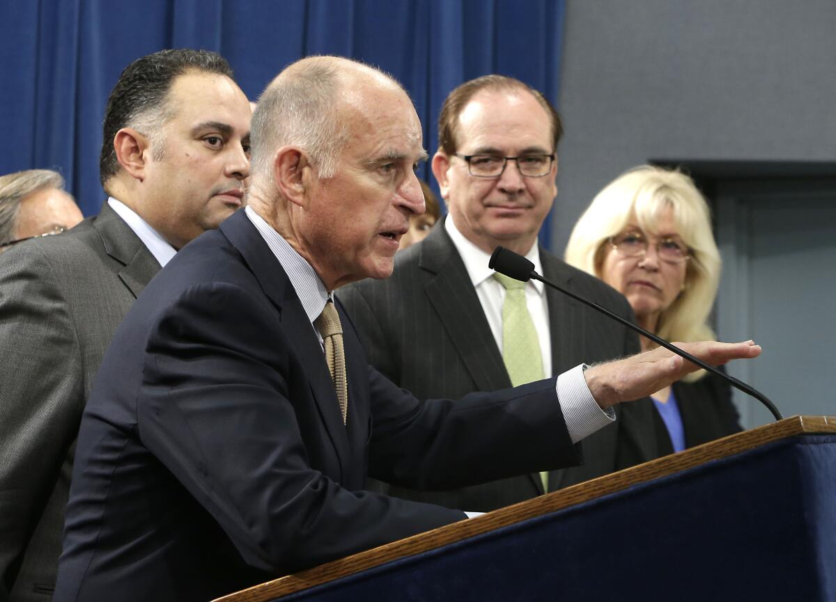 At a Capitol news conference in Sacramento, Gov. Jerry Brown, center, discusses a proposal to reduce California's prison population.