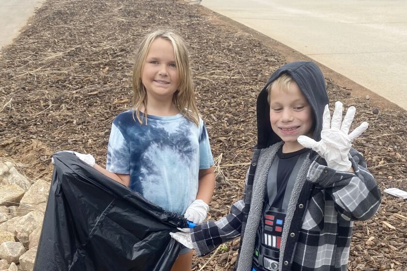 James Dukes Elementary students Harlie Fields, left, and Brooks Palma helped pick up trash in the Estates after a storm. 