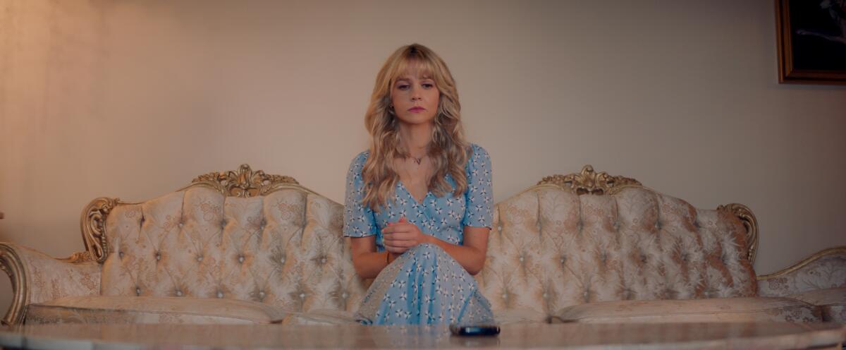 Cassandra (played by Carey Mulligan) sits on a gaudy couch in her parents' home in "Promising Young Woman"
