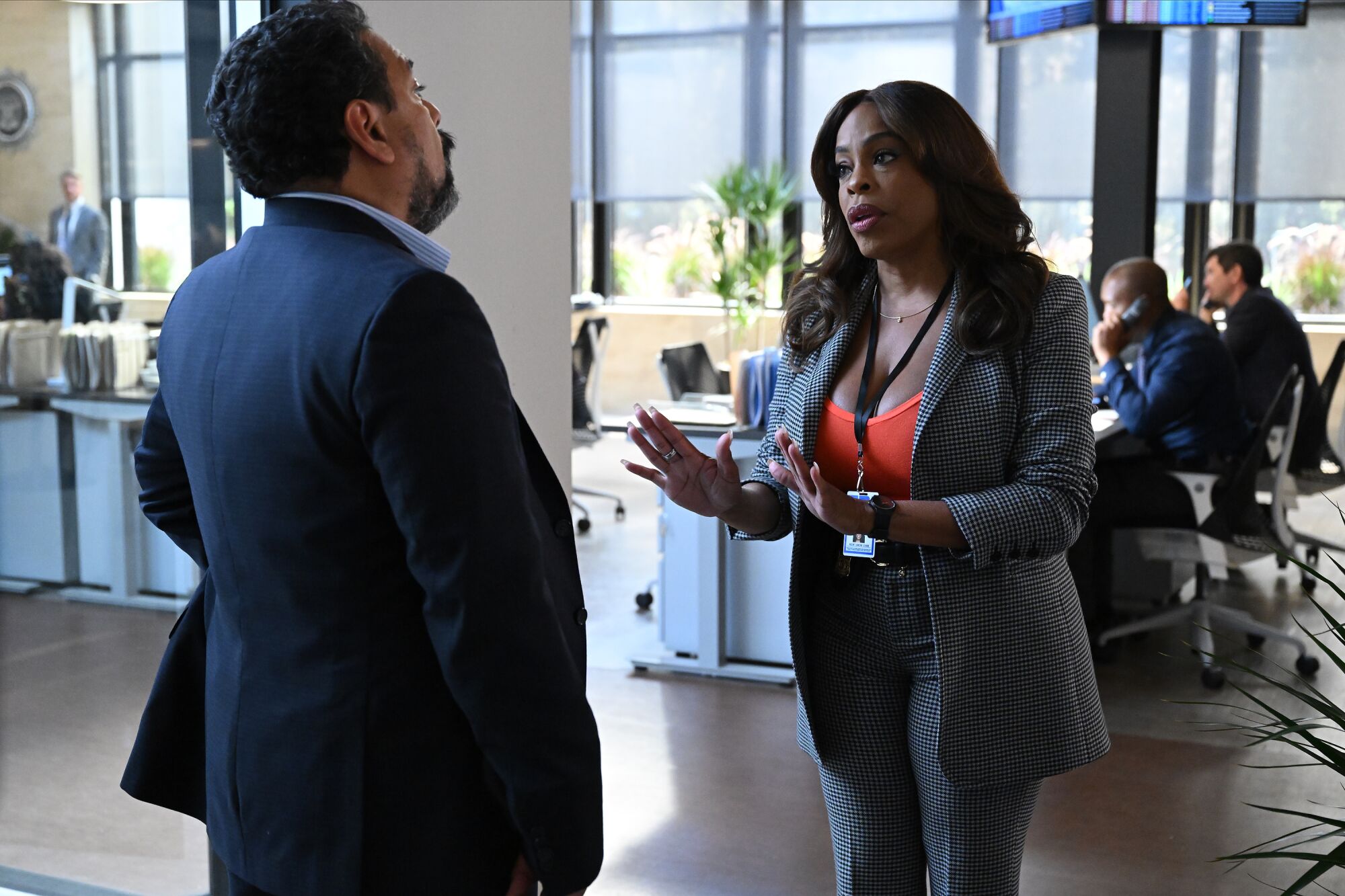 A woman reassures a male colleague in an office.