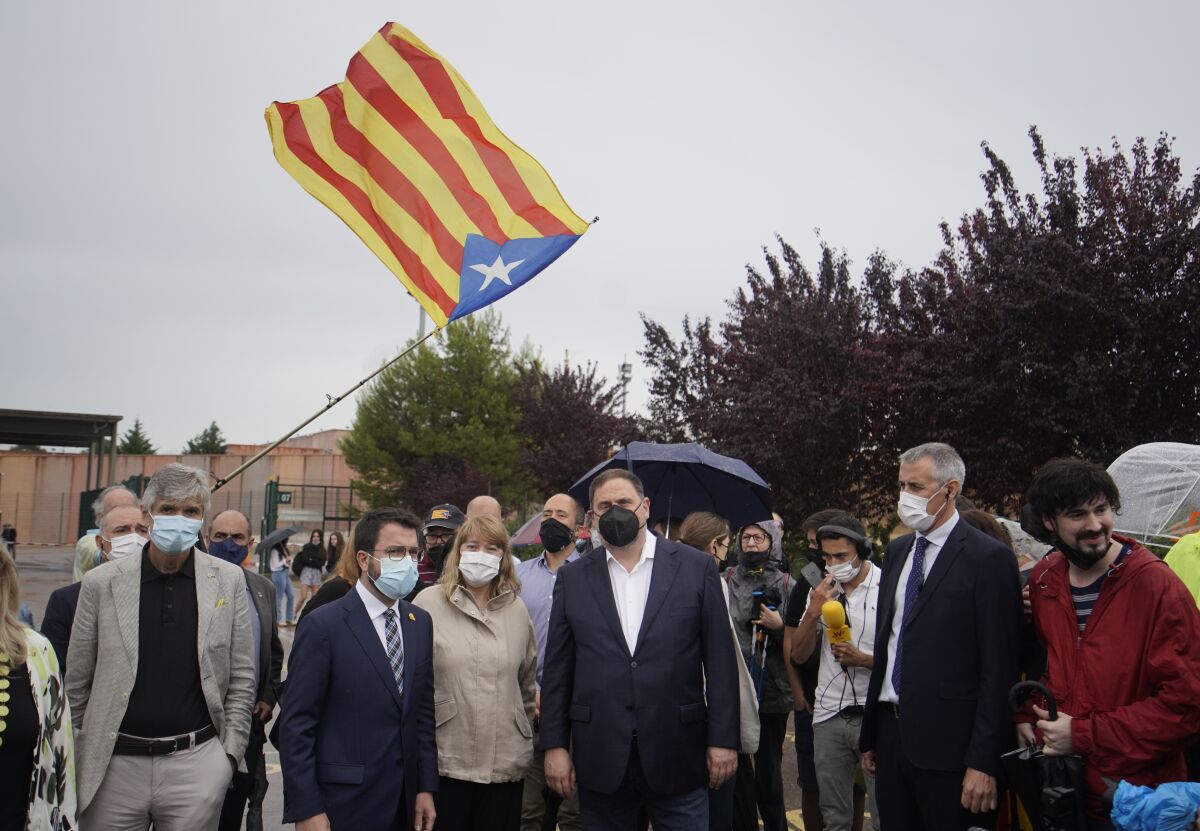 FILE - Former deputy president of the Catalan regional government Oriol Junqueras, centre, walks with the current Catalonian president Pere Aragones, 2nd left, in front of an "estelada" or Catalan pro-independence flag after being released from the Lledoners prison in Sant Joan de Vilatorrada near Barcelona, Spain, June 23, 2021. The phones of dozens of pro-independence supporters in Spain's northeastern Catalonia, including the regional chief and other elected officials, were hacked with controversial spyware available only to governments, a cybersecurity rights nonprofit said Monday April 18, 2022. (AP Photo/Joan Mateu, File)