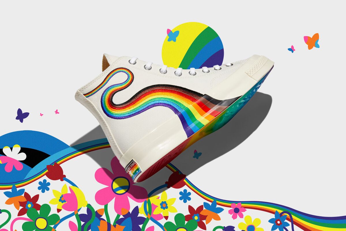Photo of white Converse high-tops with a rainbow curling down the side.