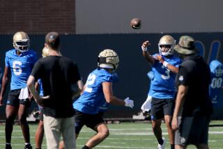 UCLA quarterback Dante Moore (3) warms up by passing the ball during practice