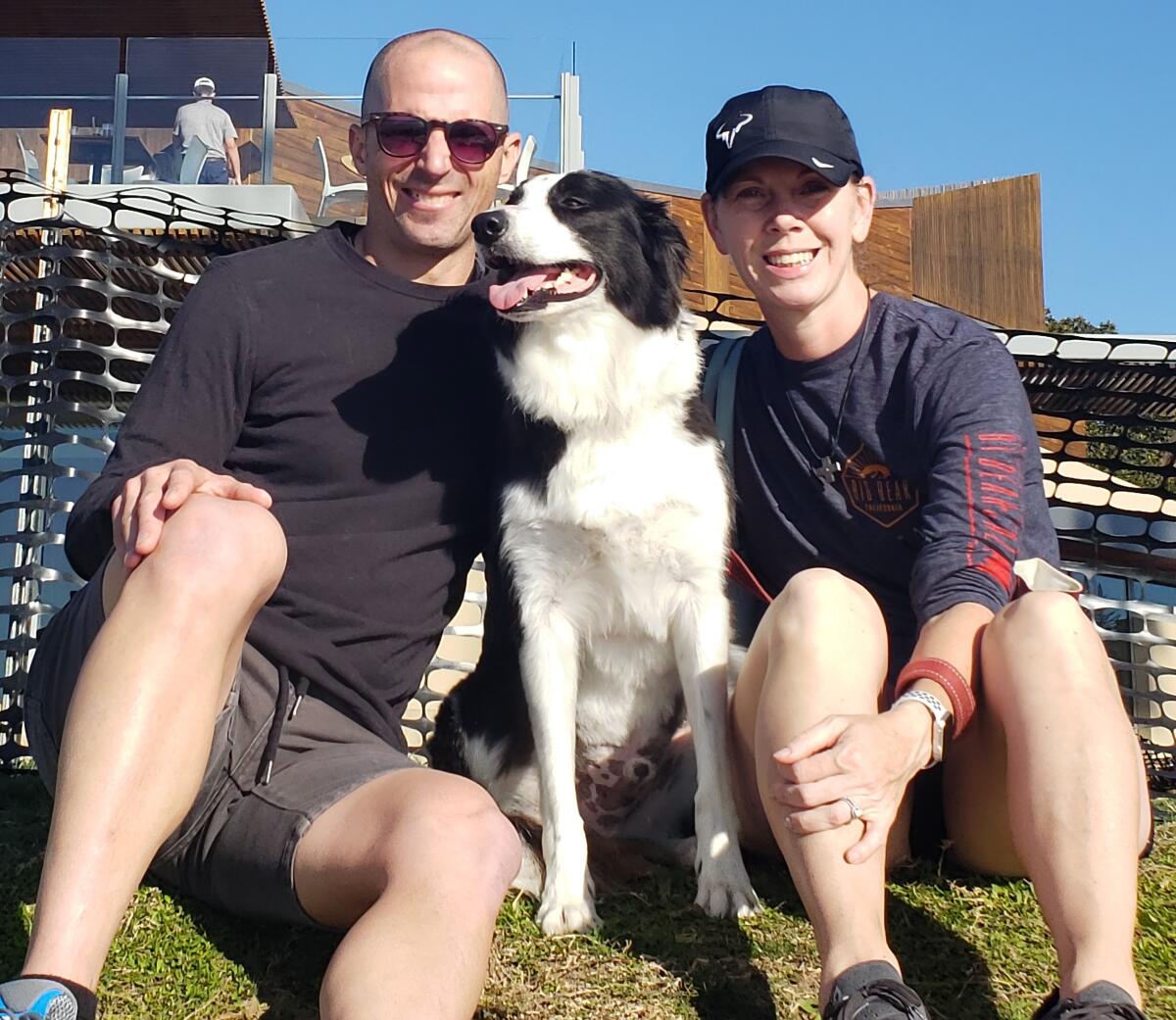 Scott and Erica Thomas relax with their border collie, Bobby, who is the mascot for their Bobby’s Pet Grooming business.