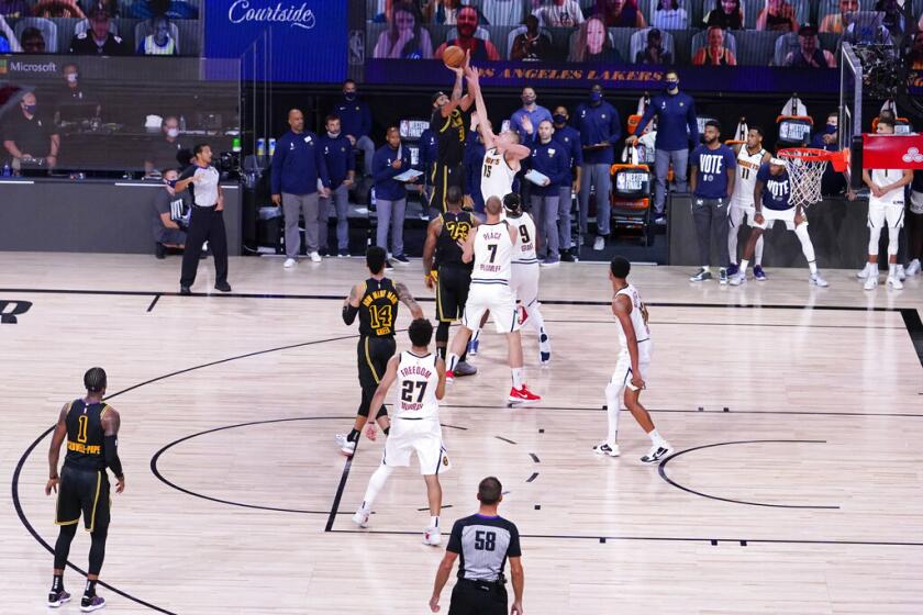 Anthony Davis de los Lakers de Los Angeles (3) tira una canasta de 3 puntos sobre Nikola Jokic de los Nuggets de Denver