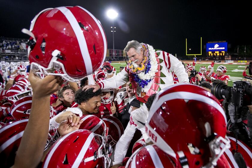 Mission Viejo, CA - December 11: Mater Dei coach Bruce Rollinson is hoisted on the shoulders of his team in celebration after they beat San Mateo Serra 44-7 to win the "2021 CIF State Football Championship Bowl Games Open Division tournament at Saddleback College, Mission Viejo, CA on Saturday, Dec. 11, 2021. (Allen J. Schaben / Los Angeles Times)