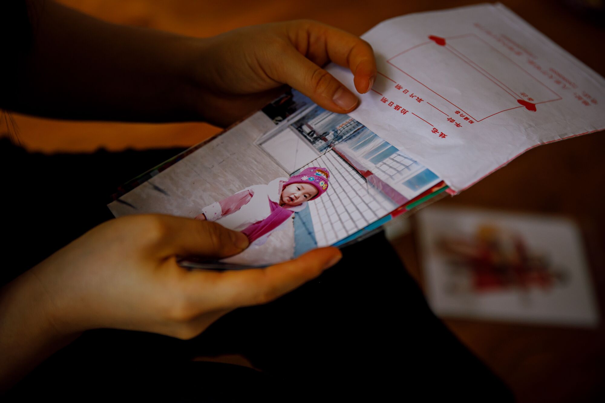 Joy Kim, 30, looks at a photo of the daughter she left behind in China when she escaped to make her way to South Korea.