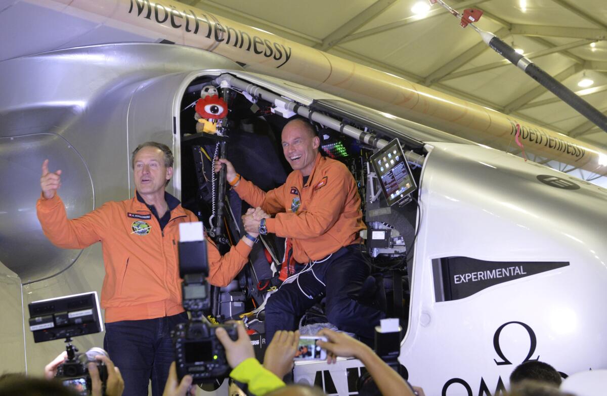 Swiss pilots Andre Boschberg, left, and Bertrand Piccard stand in the cockpit of their solar-powered plane after it touched down in Nanjing, China, on March 31. Borschberg will probably start the next leg of the trip -- crossing the Pacific Ocean to Hawaii -- on Monday.
