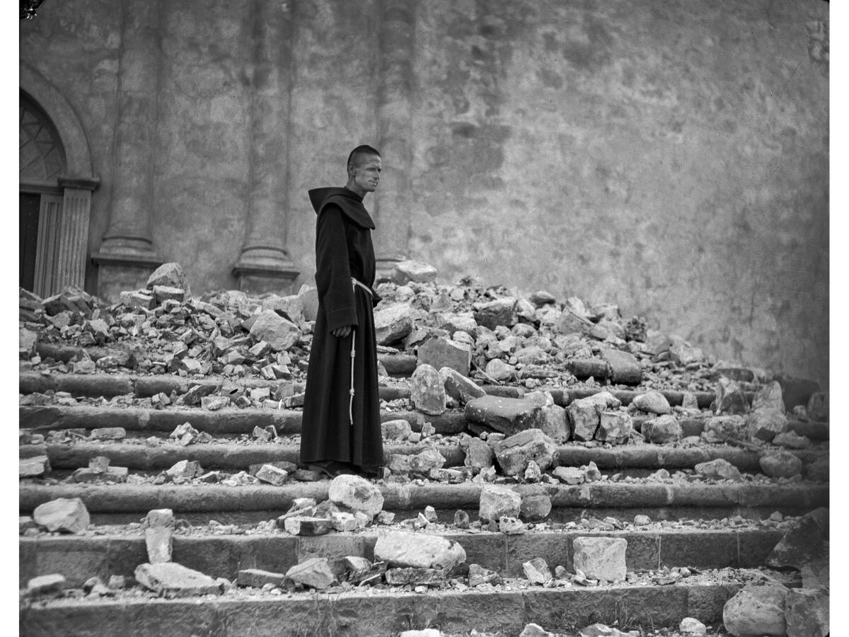 June 29, 1925: Brother Michael Lamm, one of the Franciscan friars, stands on the steps of the earthquake-damaged Mission Santa Barbara.