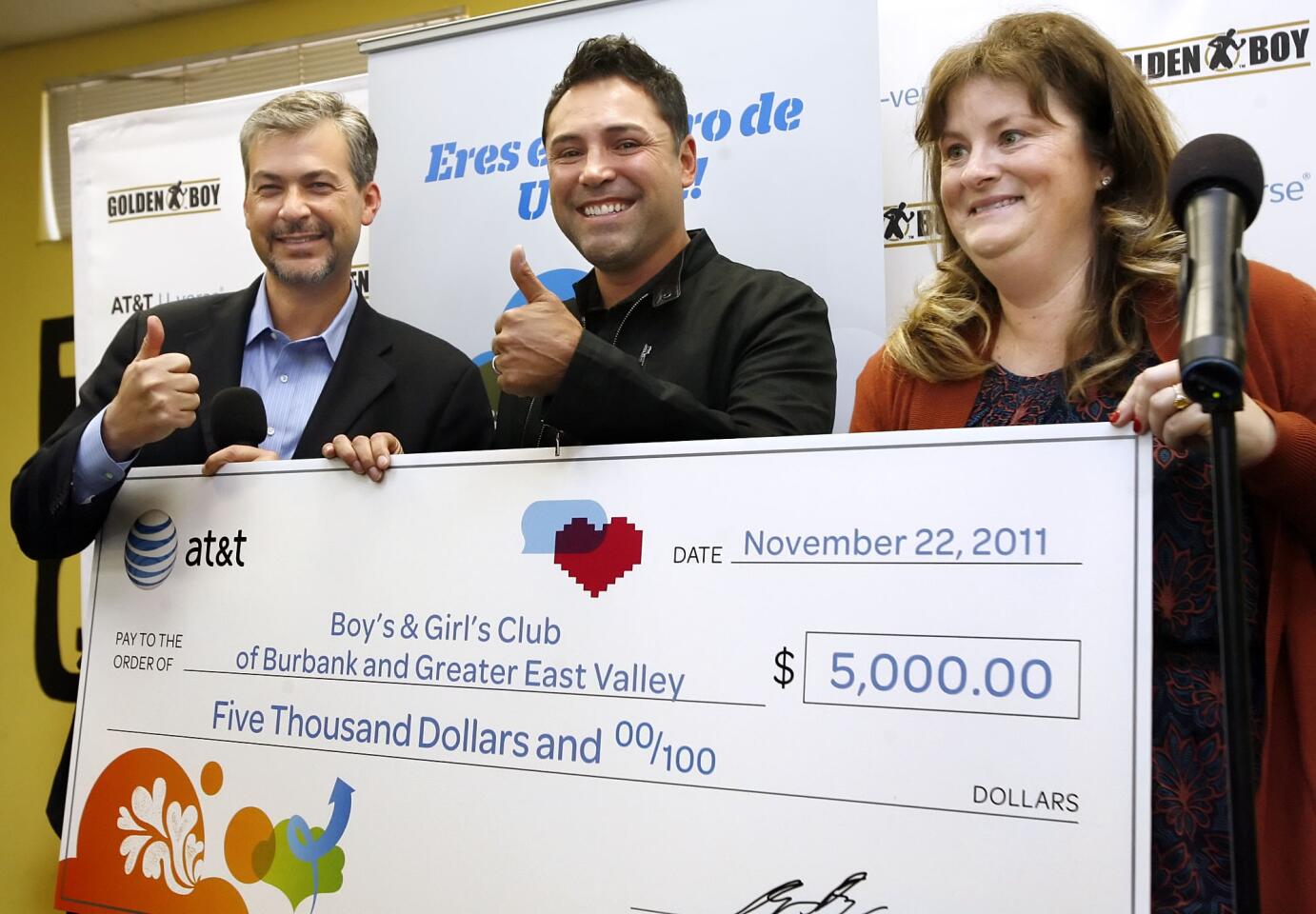 From left AT&T VP and Greater L.A. GM Andy Shibley, Ten-time World Champion boxer Oscar de la Hoya and Boys & Girls Club CEO Shanna Warren with check donation during AT&T press conference on Tuesday, November 22, 2011.