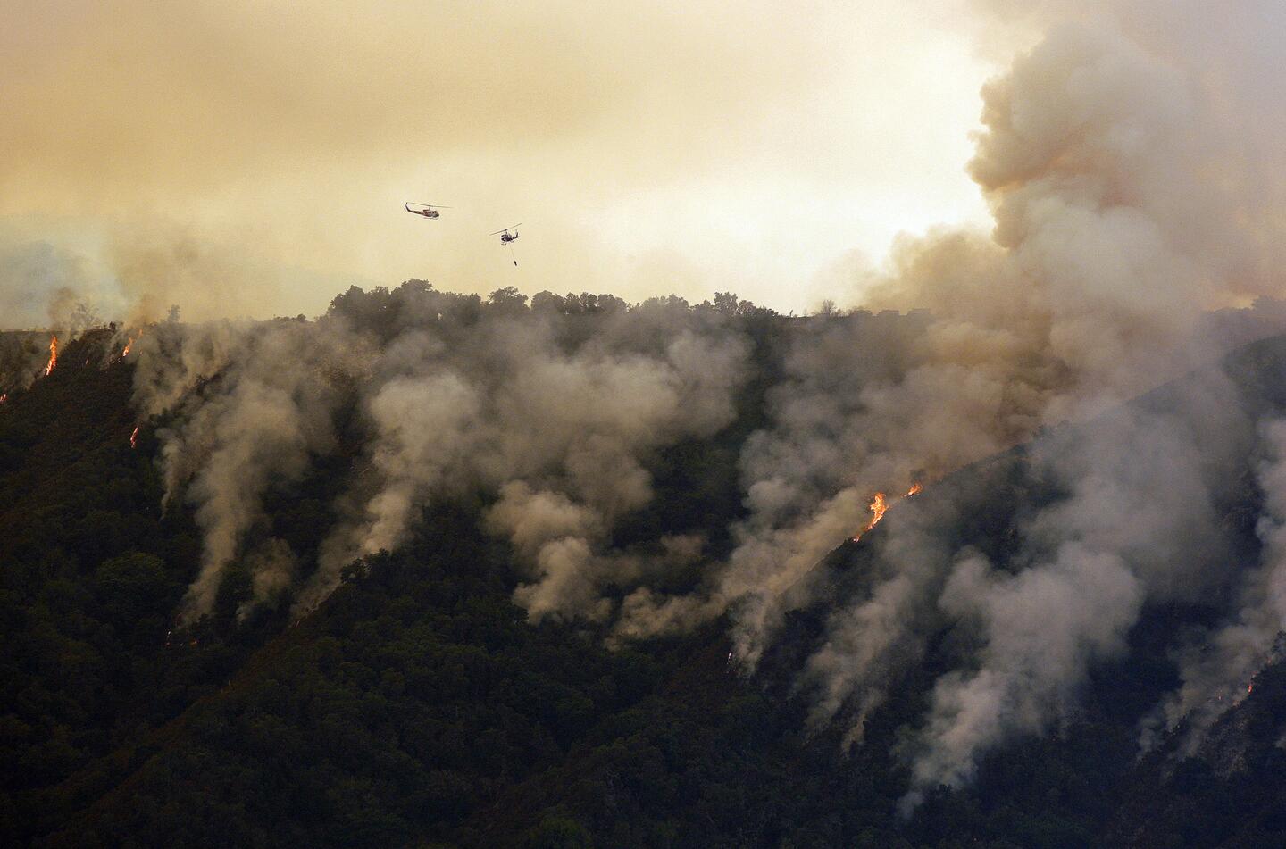 Helicopters work the Soberanes Fire west of Cachagua, Calif. A wildfire north of Big Sur near California's Central Coast has grown again overnight after burning for nearly two weeks.