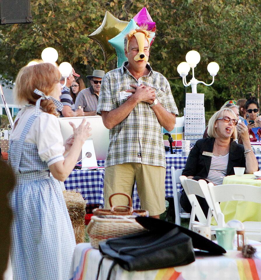 Cowardly Lion Woody Walker, who is a veterinarian in La Ca-ada, stages a little off stage performance while Glenda Morgan Brown, of Van Nuys, performs a Wizard of Oz skit at Olberz Park in La Ca-ada Flintridge at the annual La Ca-ada Flintridge Chamber of Commerce mixer on Thursday, September 17, 2015. The theme is the Wizard of Oz.