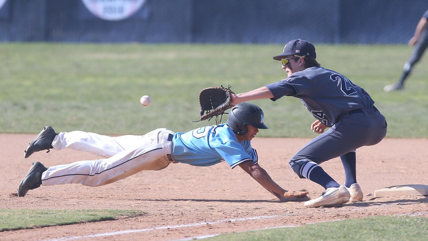 Marina's Zane Parmenter dives back to first safely as Newport Harbor first baseman Braham Duncan makes the catch in a Wave League game on Tuesday.