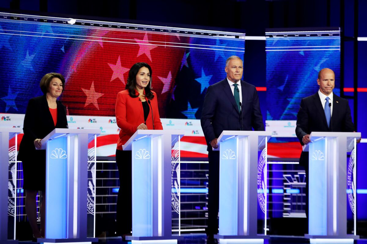 From left, Minnesota Sen. Amy Klobuchar, Hawaii Rep. Tulsi Gabbard, Washington Gov. Jay Inslee and former Maryland Rep. John Delaney participate in the candidate debate in Miami in June. All four are at risk of not making the cut for debates in the fall.