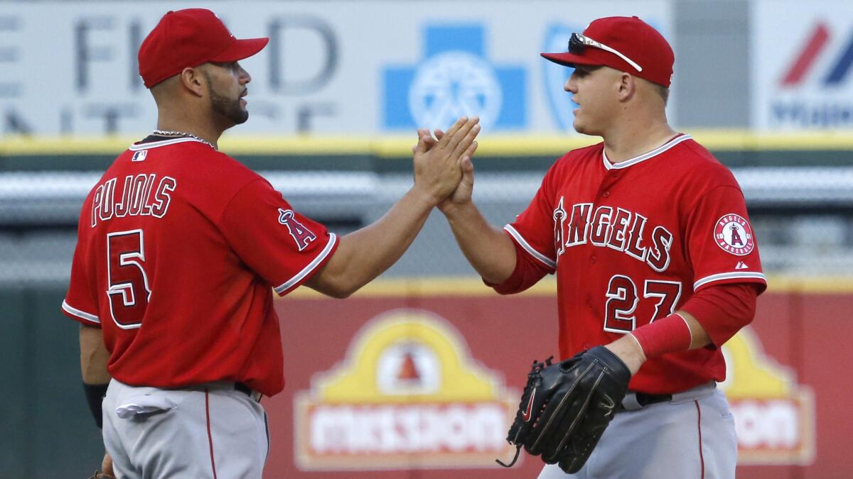 Angels teammates Albert Pujols (5) and Mike Trout (27) could be forced to move down in the lineup with Josh Hamilton out to start the season.