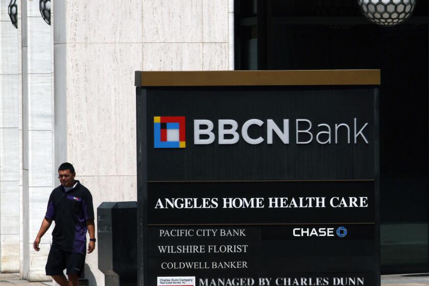 A FedEx employee walks near the BBCN Bank in Los Angeles in July 2013.