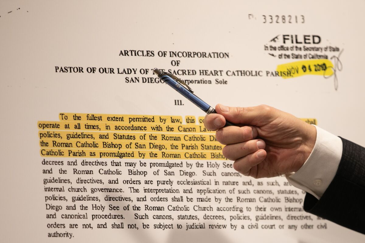 A hand uses a pen to point at documents.