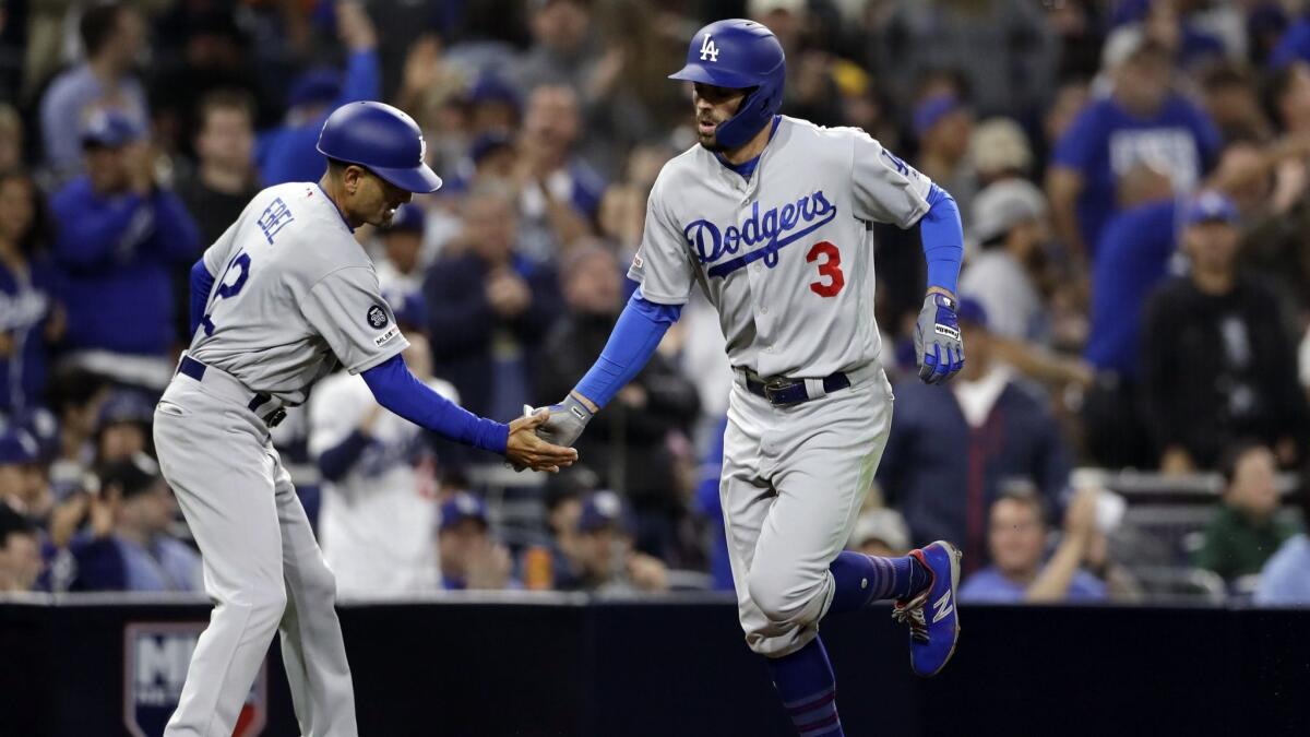 Dodgers' Chris Taylor (3) is greeted by third base coach Dino Ebel after Taylor's home run during the fifth inning against the San Diego Padres on Friday in San Diego.