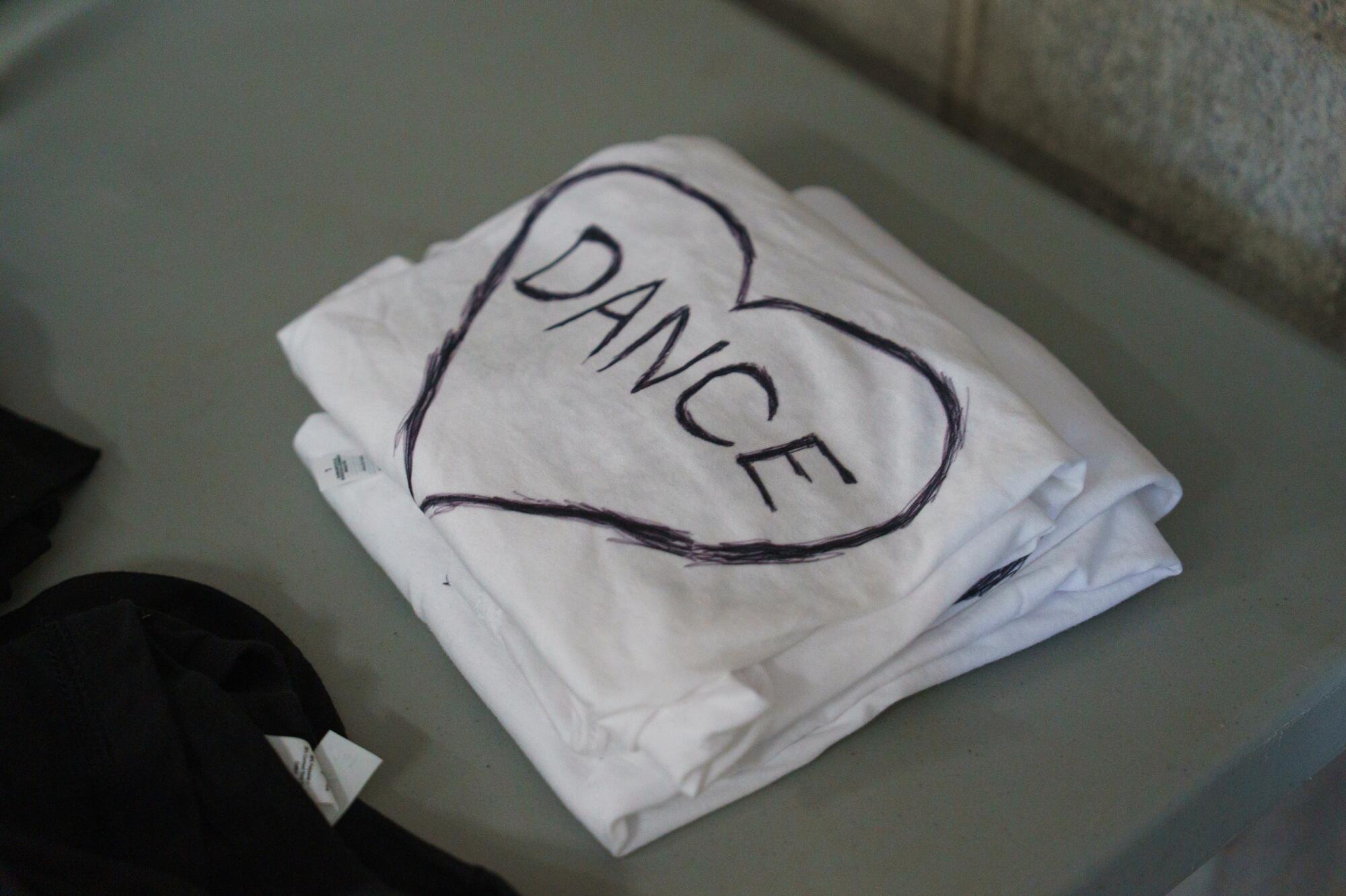 A pile of towels with the word Dance within a heart