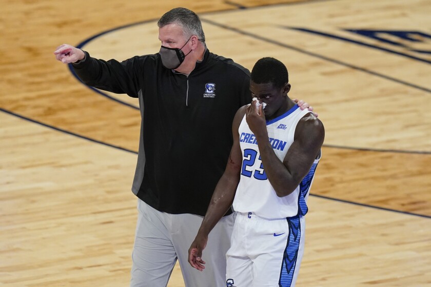 Creighton coach Greg McDermott, left, points to the bench as he helps Damien Jefferson (23) after Jefferson was hurt during the first half of the team's NCAA college basketball game against Butler in the Big East men's tournament Thursday, March 11, 2021, in New York. (AP Photo/Frank Franklin II)