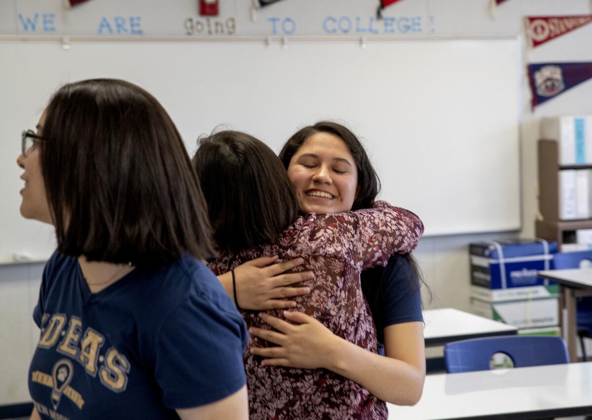 Mehraeel Gouda, left, looks on as her best friend, Katerin, hugs teacher Mercelena Vasquez-Funk.