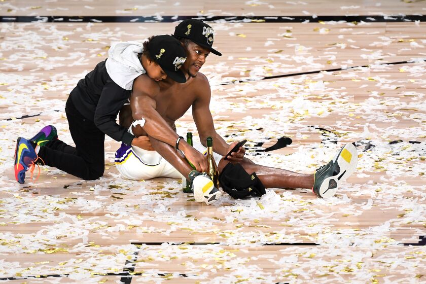 ORLANDO, FLORIDA OCTOBER 11, 2020- Lakers Rajon Rondo and is son Rajon Jr. celebrate on the court after winning the NBA Championship in Game 6 of the NBA FInals in Orlando Sunday. (Wally Skalij/Los Angeles Times)