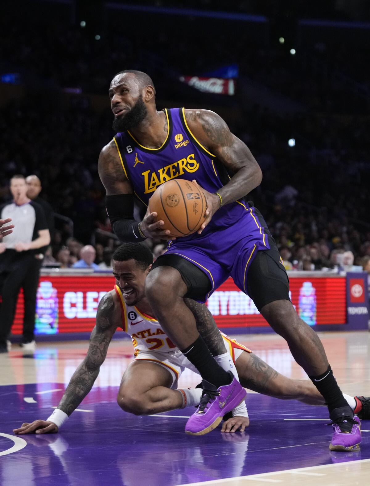 Lakers star LeBron James drives to the basket past Atlanta's John Collins during the first half Friday.