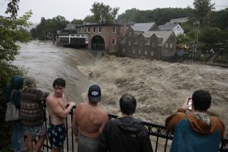 Quechee, VT - July 10: People line the railing over the Ottauquechee River to get a closer look as the river rises. (Photo by Jessica Rinaldi/The Boston Globe via Getty Images)