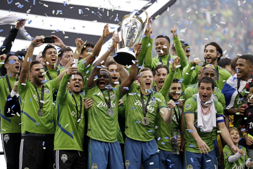 FILE - In this Nov. 10, 2019, file photo, Seattle Sounders players celebrate after beating the Toronto FC in the MLS Cup championship soccer match in Seattle. The Sounders victory was among Washington state's top news stories of 2019. (AP Photo/Elaine Thompson, File)