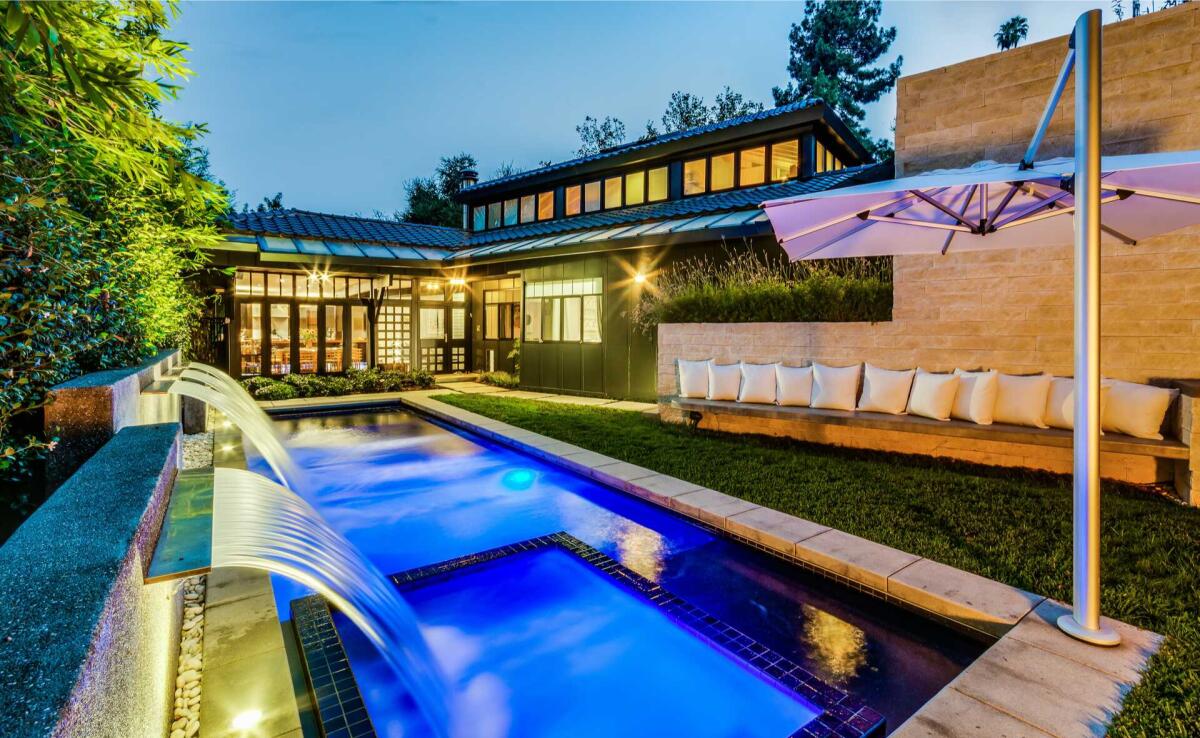 Clad in glass, the custom home expands to a garden-filled backyard with a tearoom and koi pond.