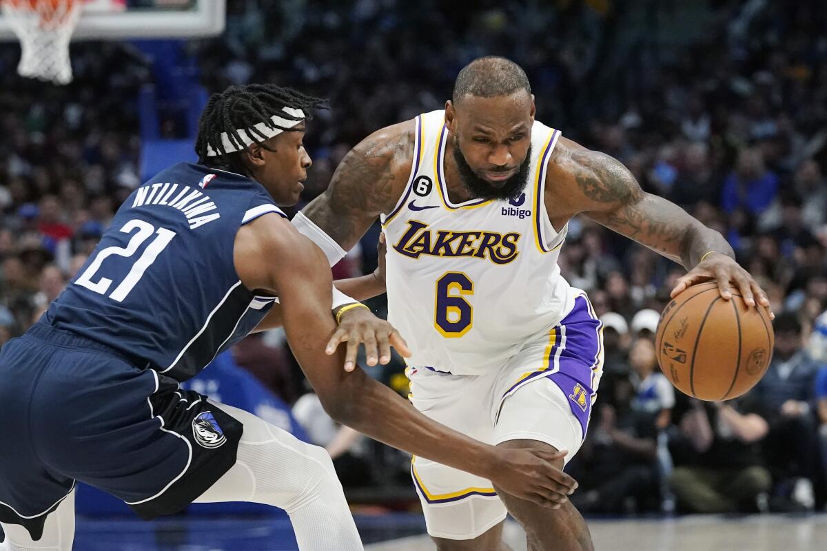 Lakers star LeBron James, right, drives against Dallas Mavericks guard Frank Ntilikina.