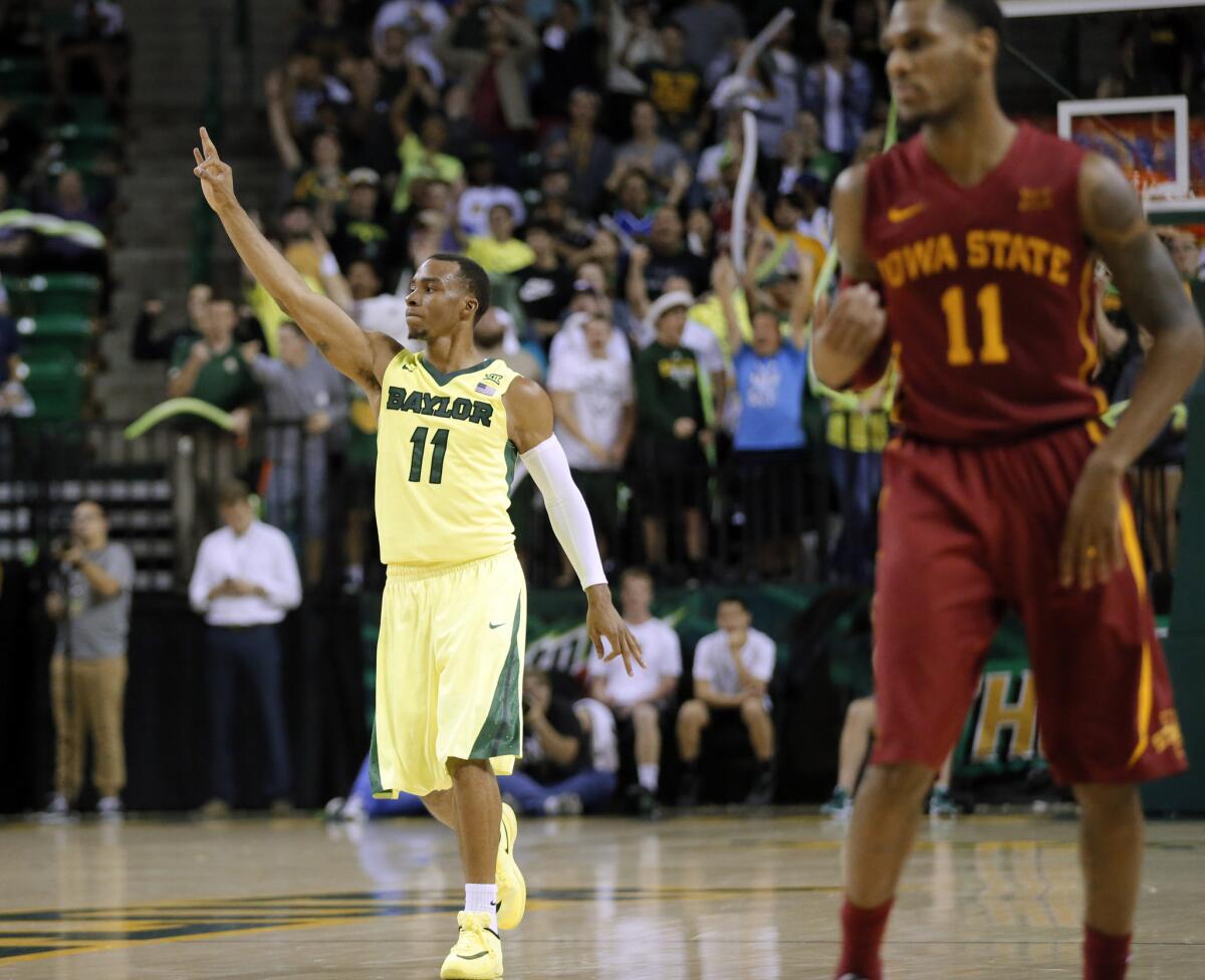 Baylor guard Lester Medford (11) celebrates at the buzzer as Iowa State's Monte Morris (11) walks back to the bench after Baylor won 100-91 in overtime.