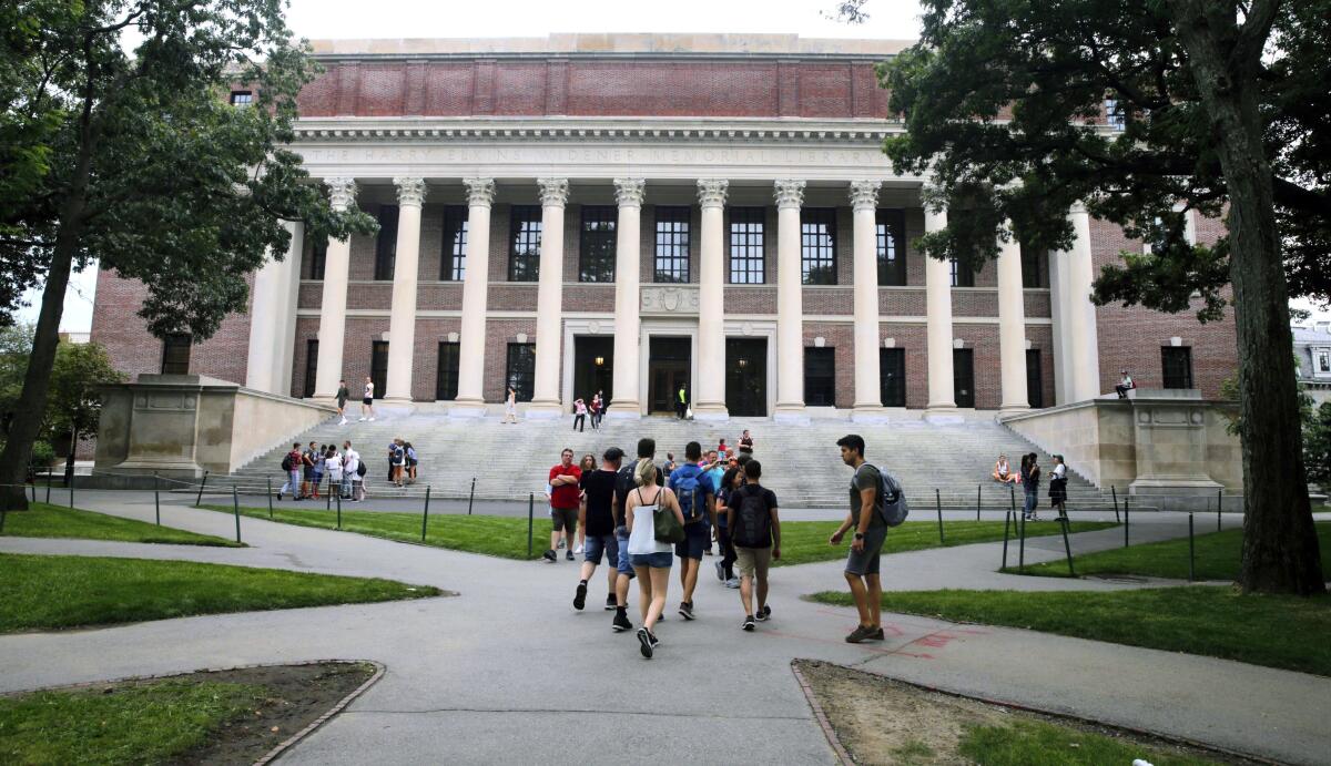 Estudiantes caminan cerca de la biblioteca Widener en la Universidad de Harvard en Cambridge, Massachusetts.