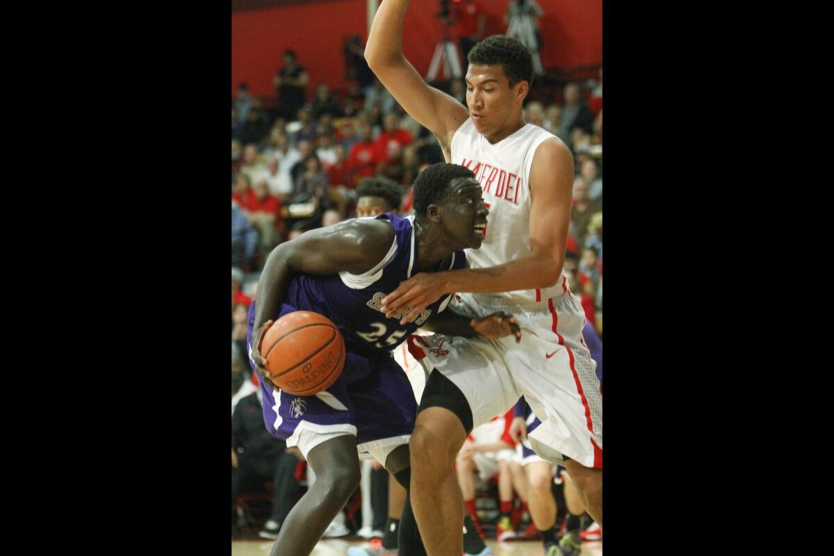 St. Augustine's Martin Tombe goes up against Mater Dei's Michael Cage in the first half.